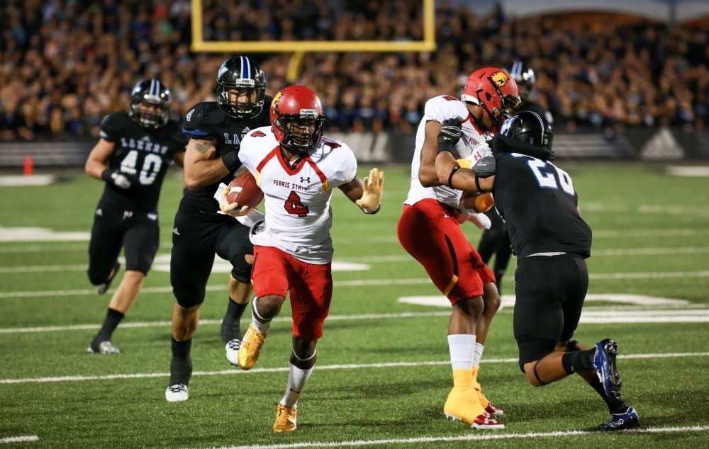 GVL / Kevin Sielaff      Troy Smith (4) of Ferris runs the ball through Grand Valley's defense. Grand Valley State University squares off against Ferris State University Sept. 19 at Lubbers Stadium in Allendale. The Lakers were defeated, with a final score of 61-24.