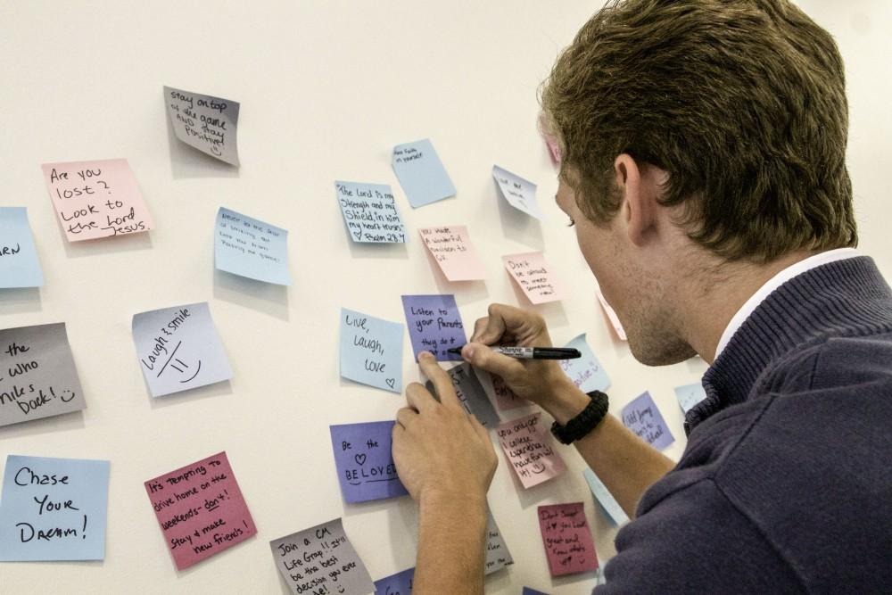 GVL / Sara Carte
Grand Valley student, Brenden McGuire, shares a piece of his advice with the student body at the Letters to Lakers sticky note exhibit in the Atrium level of the Mary Idema Pew Library on Thursday, September 10, 2015. 