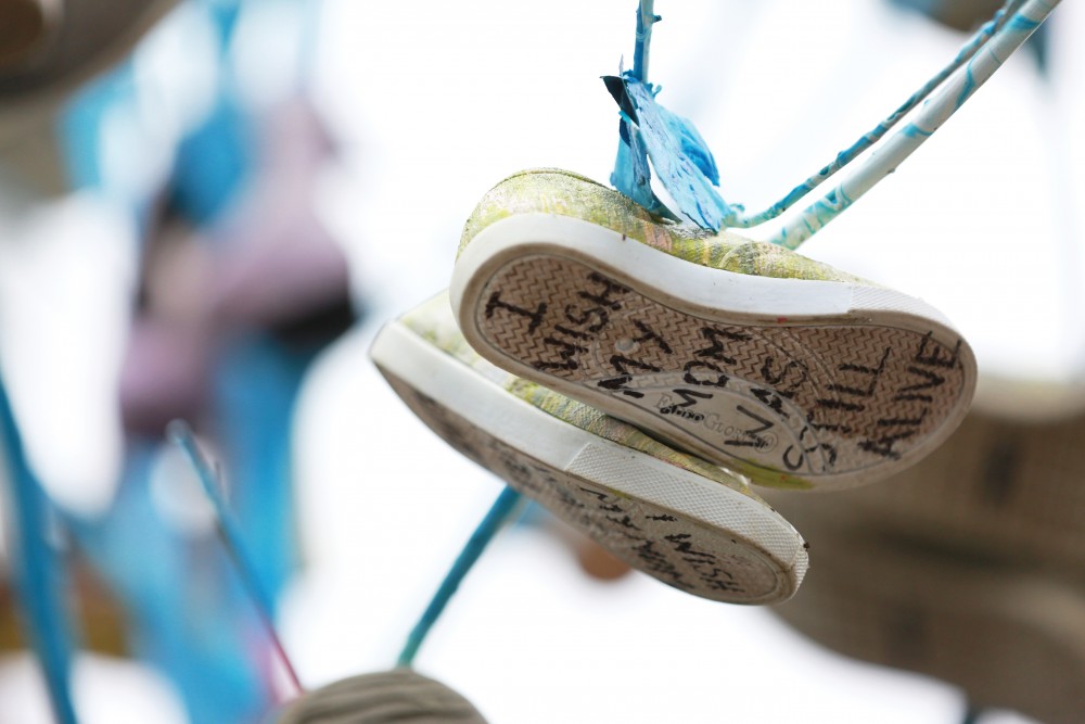 GVL / Kevin Sielaff  
Janelle Dahlberg's piece entitled "Phenomena 117" consists of shoes hanging on a tree which have statements or wishes written on the soles. Grand Rapids' annual ArtPrize is held from Sept. 23 - Oct. 1 at various locations around the city. 