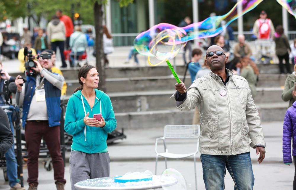 GVL / Kevin Sielaff  
David Adams waves a bubble wand in Rose Parks Circle. Grand Rapids' annual ArtPrize is held from Sept. 23 - Oct. 1 at various locations around the city. 