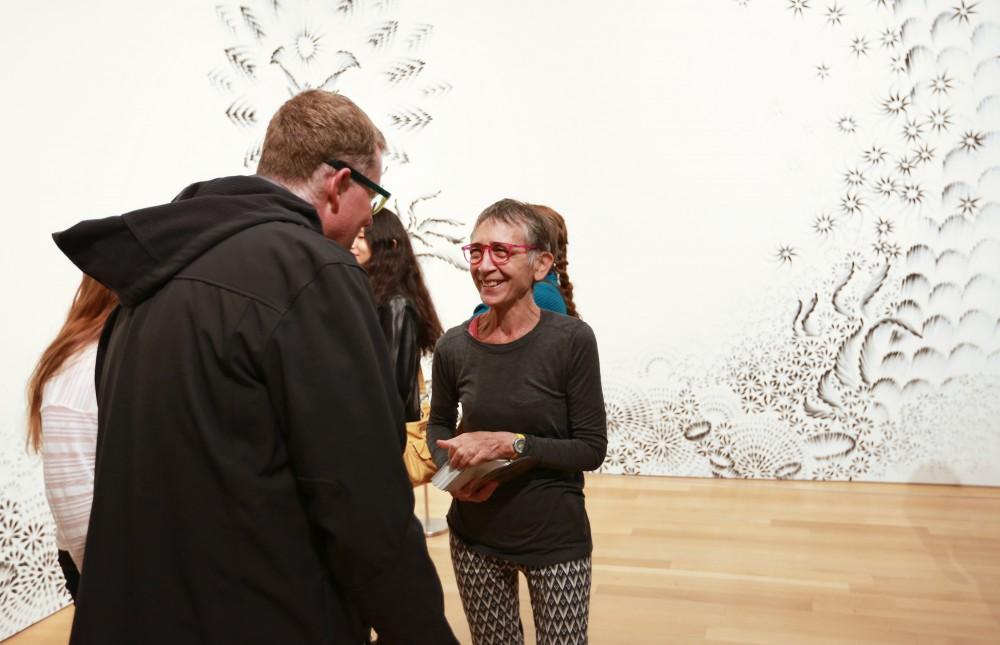 GVL / Kevin Sielaff  
Top 20 artist Judith Braun stands with her charcoal finger painting "As Above" and speaks with Grand Rapids Art Museum director Dana Friis-Hansen. Grand Rapids' annual ArtPrize is held from Sept. 23 - Oct. 1 at various locations around the city. 