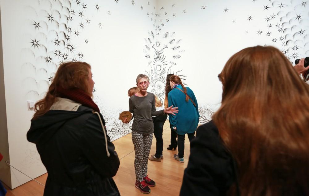 GVL / Kevin Sielaff  
Top 20 artist Judith Braun stands with her charcoal finger painting "As Above" and speaks with spectators. Grand Rapids' annual ArtPrize is held from Sept. 23 - Oct. 1 at various locations around the city. 