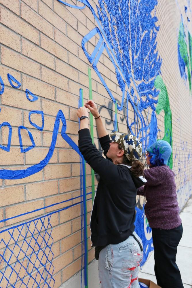 GVL / Kevin Sielaff  
Leah Smith and Joan Townsend work on their tape drawing on 4 East Fulton Street. Grand Rapids' annual ArtPrize is held from Sept. 23 - Oct. 1 at various locations around the city. 