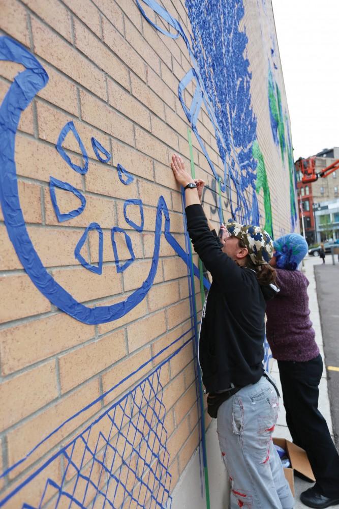 GVL / Kevin Sielaff  
Leah Smith and Joan Townsend work on their tape drawing on 4 East Fulton Street. Grand Rapids' annual ArtPrize is held from Sept. 23 - Oct. 1 at various locations around the city. 