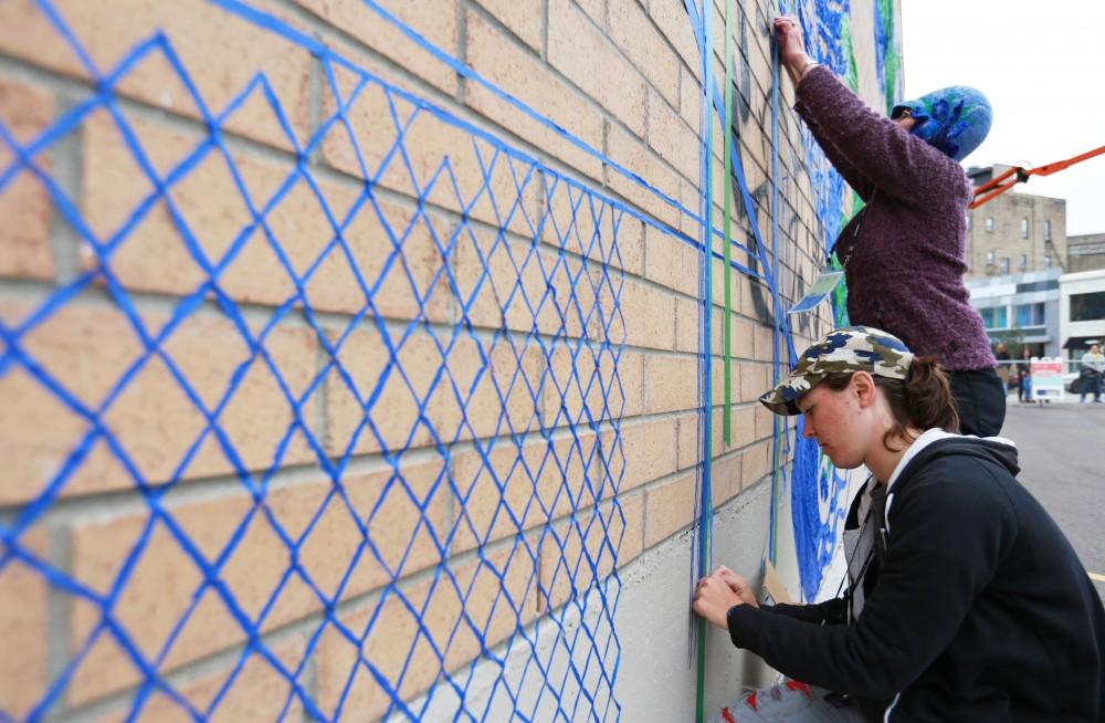 GVL / Kevin Sielaff  
Leah Smith and Joan Townsend work on their tape drawing on 4 East Fulton Street. Grand Rapids' annual ArtPrize is held from Sept. 23 - Oct. 1 at various locations around the city. 