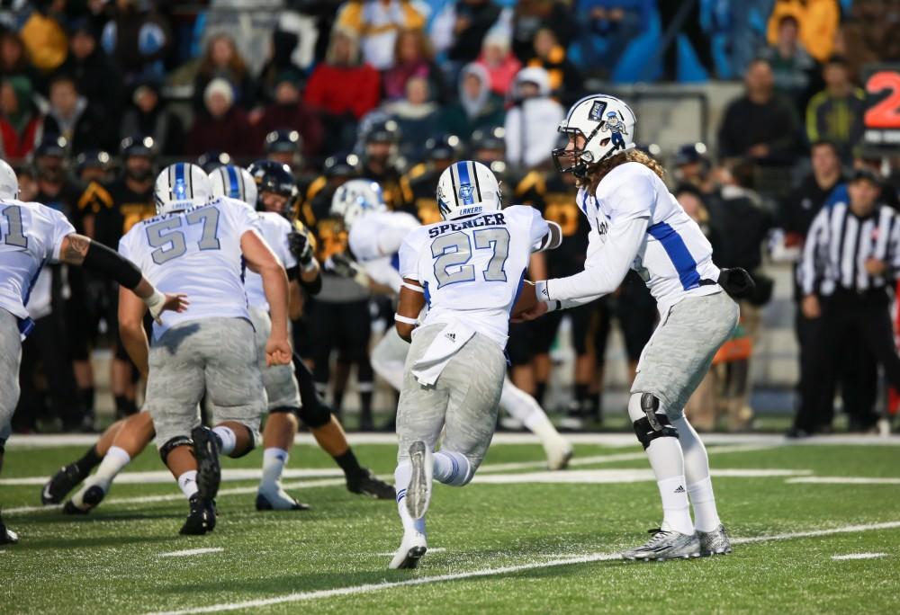 GVL / Kevin Sielaff -  Bart Williams (6) hands the ball off to Kirk Spencer (27). Grand Valley squares off against Michigan Tech Oct. 17 at Lubbers Stadium in Allendale. The Lakers defeated the Huskies with a score of 38-21.