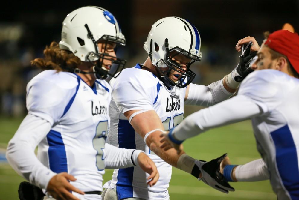 GVL / Kevin Sielaff -  Jamie Potts (15) is congratulated by his teammates after a touchdown. Grand Valley squares off against Michigan Tech Oct. 17 at Lubbers Stadium in Allendale. The Lakers defeated the Huskies with a score of 38-21.