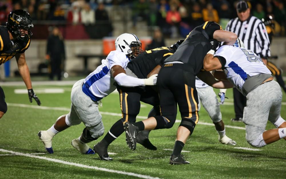 GVL / Kevin Sielaff -  Matt Judon (9) wrestles a Huskie to the ground. Grand Valley squares off against Michigan Tech Oct. 17 at Lubbers Stadium in Allendale. The Lakers defeated the Huskies with a score of 38-21.