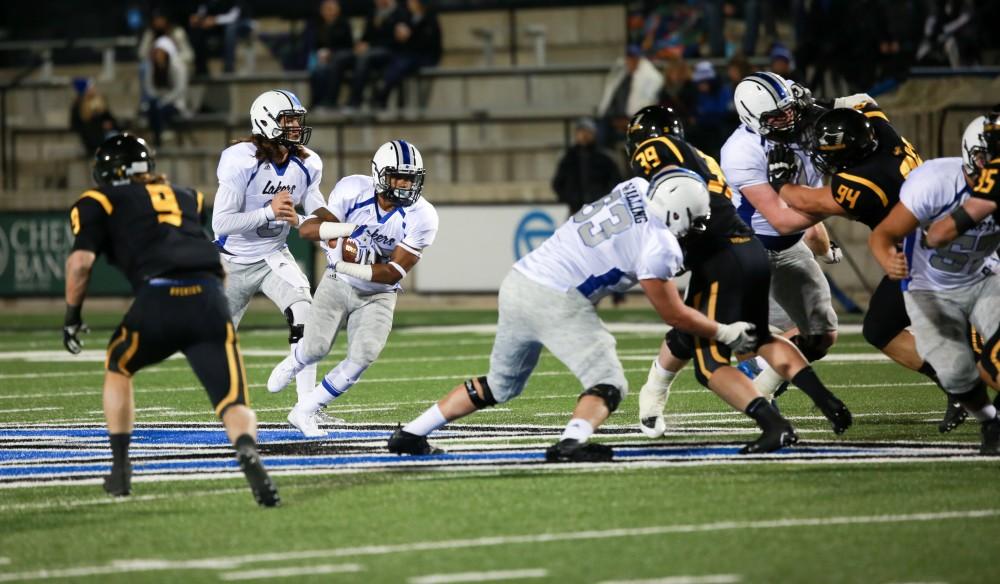 GVL / Kevin Sielaff - Bart Williams (6) hands the ball off to Kirk Spencer (27).  Grand Valley squares off against Michigan Tech Oct. 17 at Lubbers Stadium in Allendale. The Lakers defeated the Huskies with a score of 38-21.