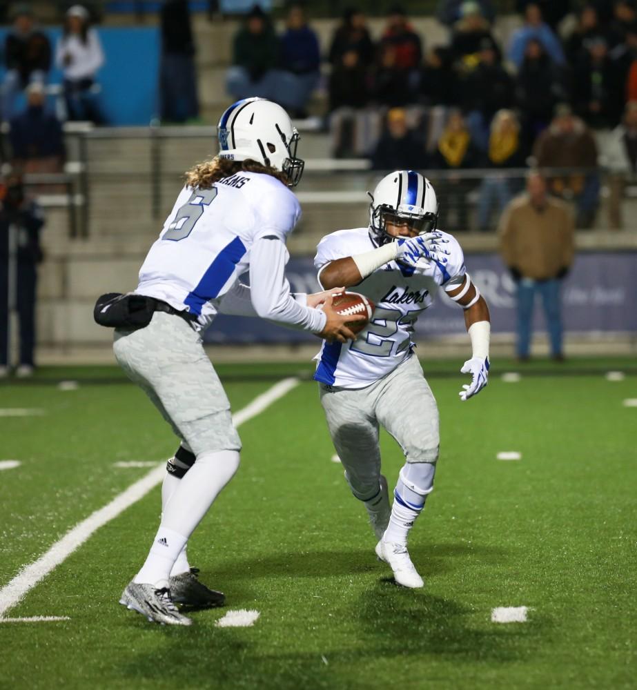 GVL / Kevin Sielaff -  Bart Williams (6) hands the ball off to Kirk Spencer (27).  Grand Valley squares off against Michigan Tech Oct. 17 at Lubbers Stadium in Allendale. The Lakers defeated the Huskies with a score of 38-21.