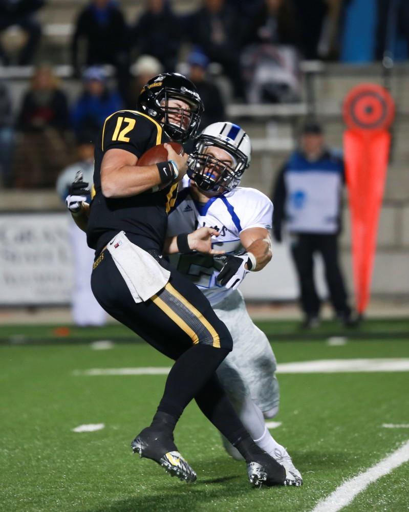 GVL / Kevin Sielaff -  Garrett Pougnet (25) delivers a strong hit to QB Brandon Cowie (12). Grand Valley squares off against Michigan Tech Oct. 17 at Lubbers Stadium in Allendale. The Lakers defeated the Huskies with a score of 38-21.