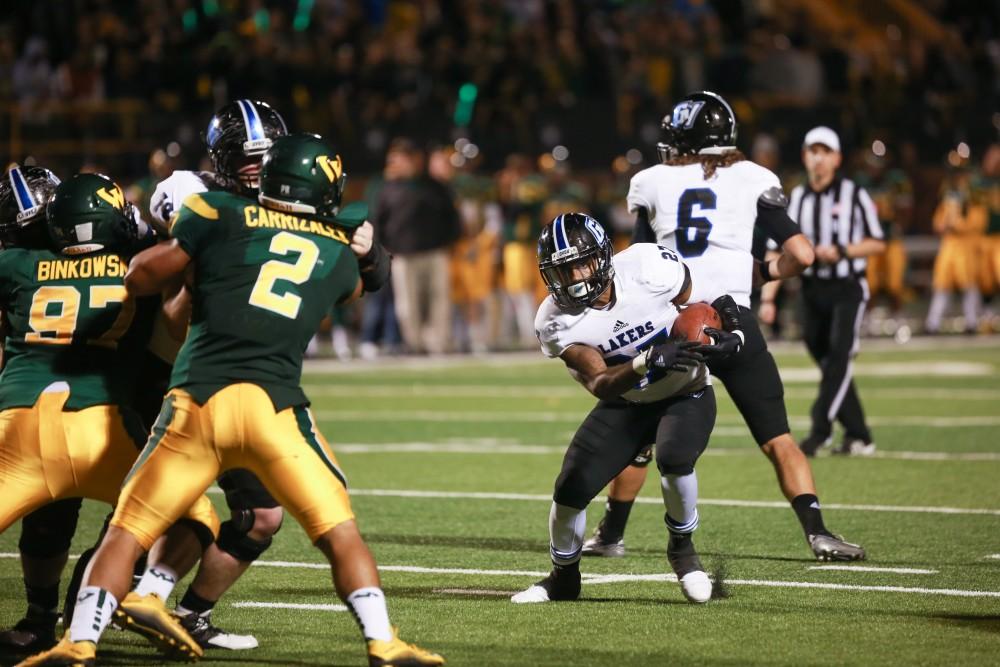 GVL / Kevin Sielaff - Kirk Spencer (27) jukes and heads to the endzone. Grand Valley squares off against Wayne State University Oct. 11 in Detroit, MI. The Lakers surged to a 38-17 victory vs. the Warriors.