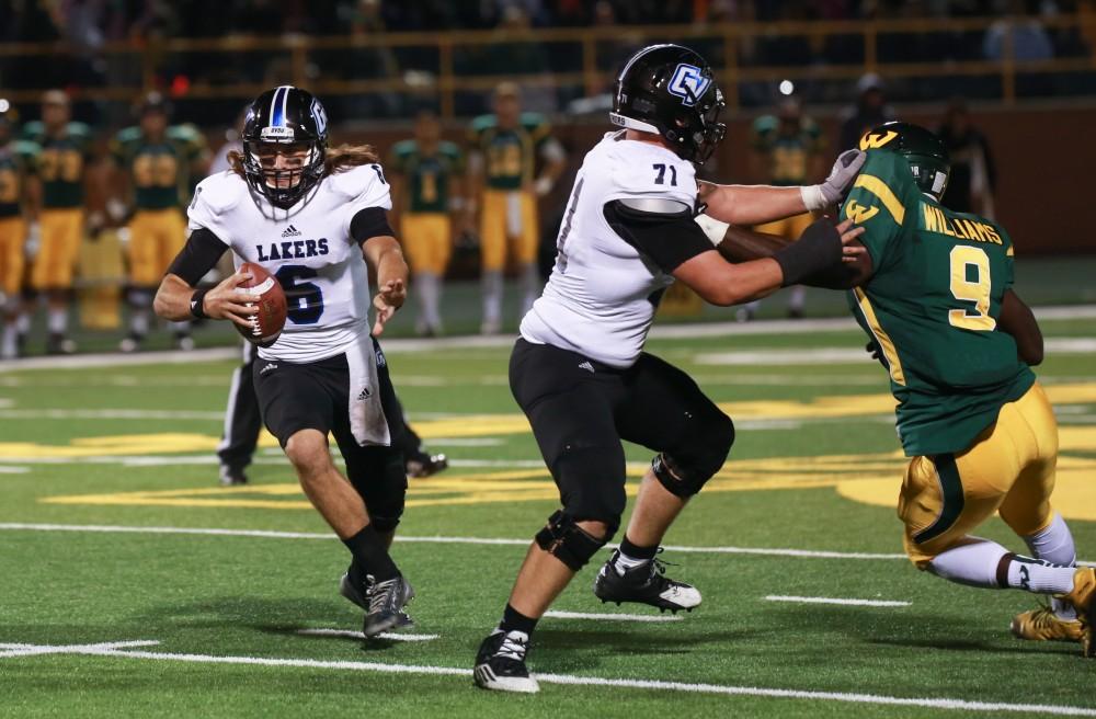 GVL / Kevin Sielaff - Bart Williams (6) runs the ball toward the endzone and receives a block from Dan DeLuca (71). Grand Valley squares off against Wayne State University Oct. 11 in Detroit, MI. The Lakers surged to a 38-17 victory vs. the Warriors.