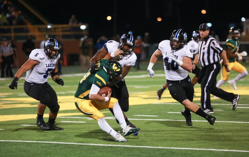 GVL / Kevin Sielaff - Matt Judon (9) wrestles Wayne State QB D.J. Zezula to the ground for a sack.  Grand Valley squares off against Wayne State University Oct. 11 in Detroit, MI. The Lakers surged to a 38-17 victory vs. the Warriors.