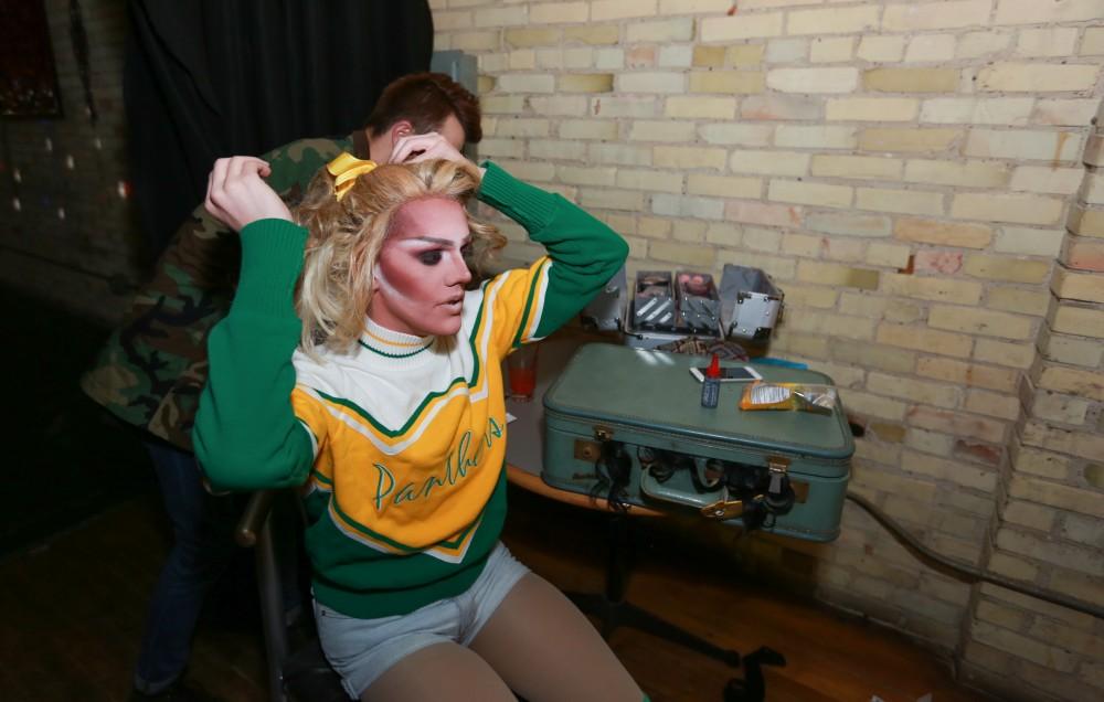 GVL / Kevin Sielaff - Drag Queen Ginger Ambrosia, otherwise known as Nathan Bentley, performs at Rumors Nightclub in Grand Rapids on Oct. 7. Brandon Wilder helps Ginger put up her hair.