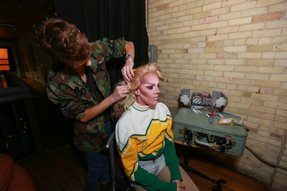 GVL / Kevin Sielaff - Drag Queen Ginger Ambrosia, otherwise known as Nathan Bentley, performs at Rumors Nightclub in Grand Rapids on Oct. 7. Brandon Wilder helps Ginger put up her hair.