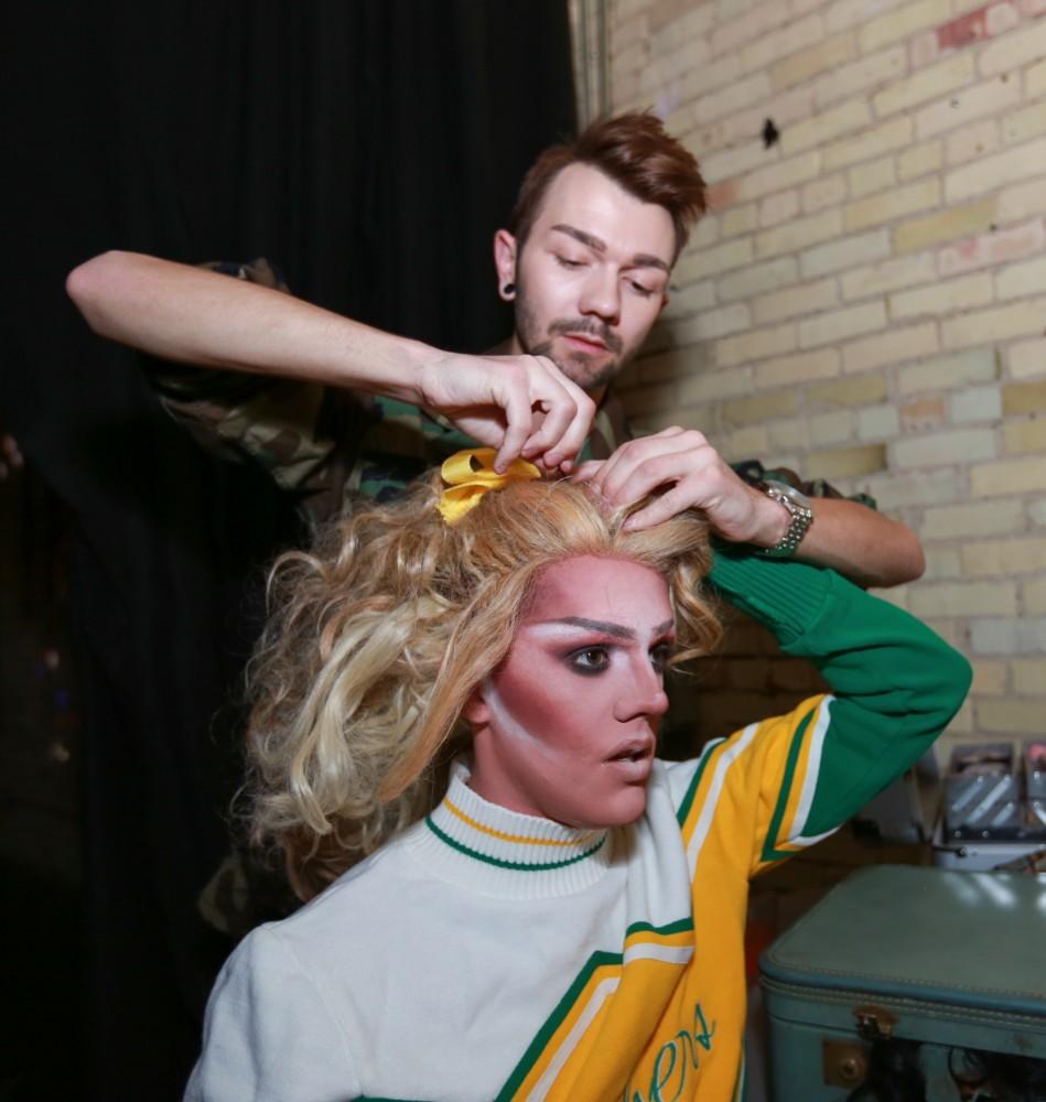 GVL / Kevin Sielaff - Drag Queen Ginger Ambrosia, otherwise known as Nathan Bentley, performs at Rumors Nightclub in Grand Rapids on Oct. 7. Brandon Wilder helps Ginger put up her hair.