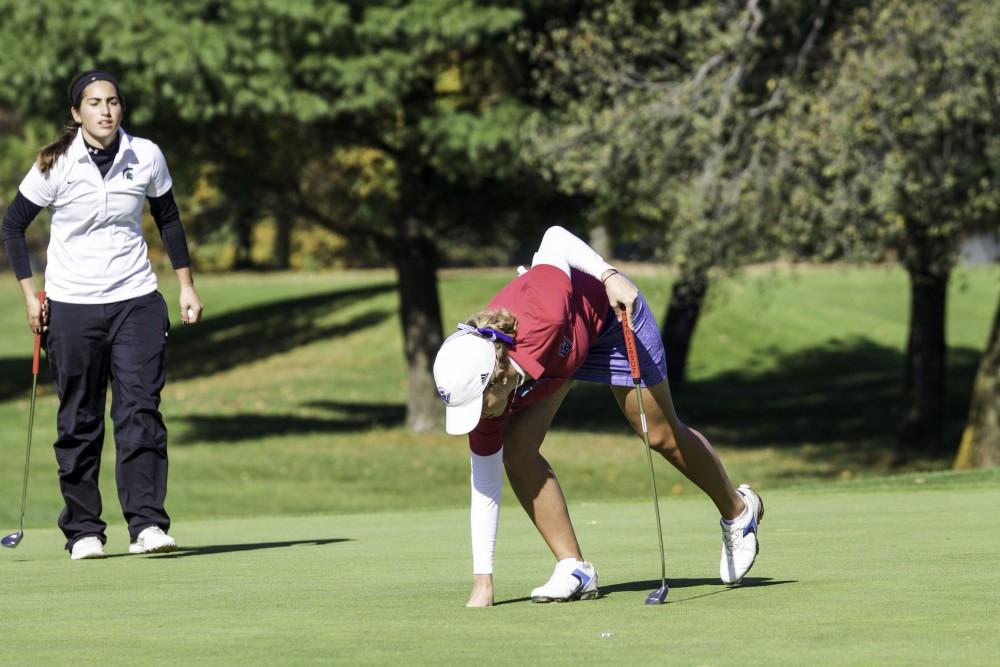 GVL / Sara Carte
Grand Valley Girl’s Golf player, Alex Taylor, grabs her ball on the ninth hole during the Davenport Invitational at the Blythefield Country Club on Oct. 26.