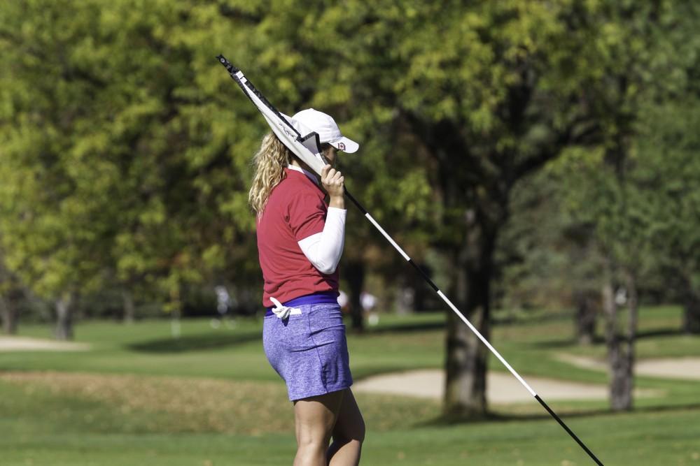 GVL / Sara Carte
Grand Valley Girl’s Golf player, Alex Taylor, puts the pin back into the putting green during the Davenport Invitational at the Blythefield Country Club on Oct. 26.