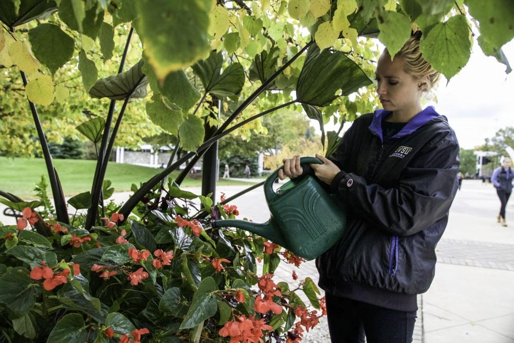 GVL / Sara Carte
Student Grounds Worker, Sarah Stanners, waters flowers next to the James H. Zumberge building on Oct. 14.