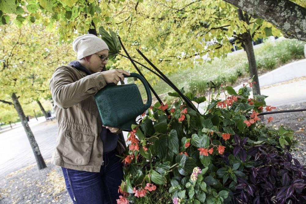 GVL / Sara Carte
Student Grounds Worker, Brooke Portwood, waters flowers next to the James H. Zumberge building on Oct. 14.