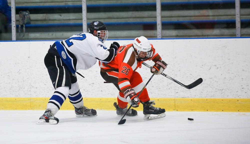 GVL / Kevin Sielaff - Zac Strain (22) pushes Bowling Green's Austin Murphy (26) toward the wall. Grand Valley's Divison II men's hockey squad squares off against Bowling Green University Oct. 16 at Georgetown Ice Arena.