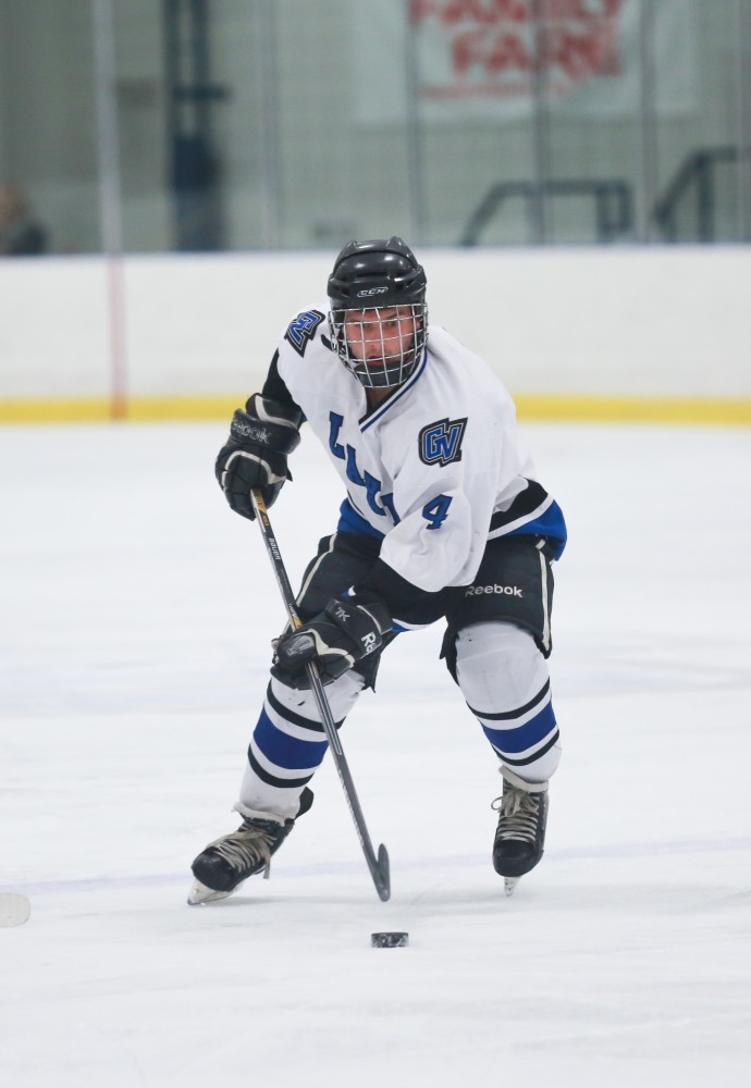 GVL / Kevin Sielaff - Tom Lusynski (4) digs the puck into Bowling Green's zone. Grand Valley's Divison II men's hockey squad squares off against Bowling Green University Oct. 16 at Georgetown Ice Arena.