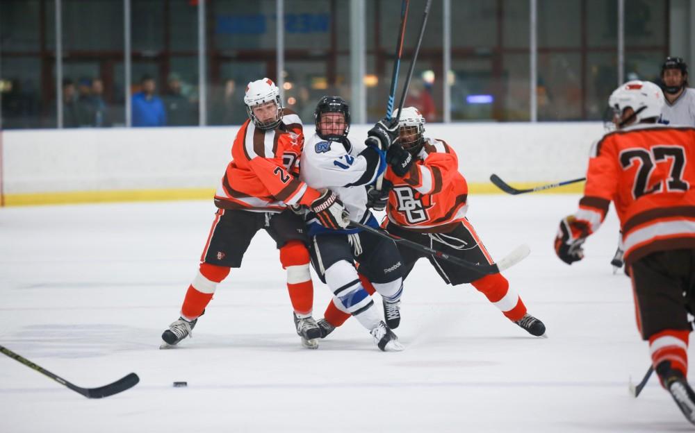 GVL / Kevin Sielaff - Reede Burnett (12) collides with two Falcons. Grand Valley's Divison II men's hockey squad squares off against Bowling Green University Oct. 16 at Georgetown Ice Arena.