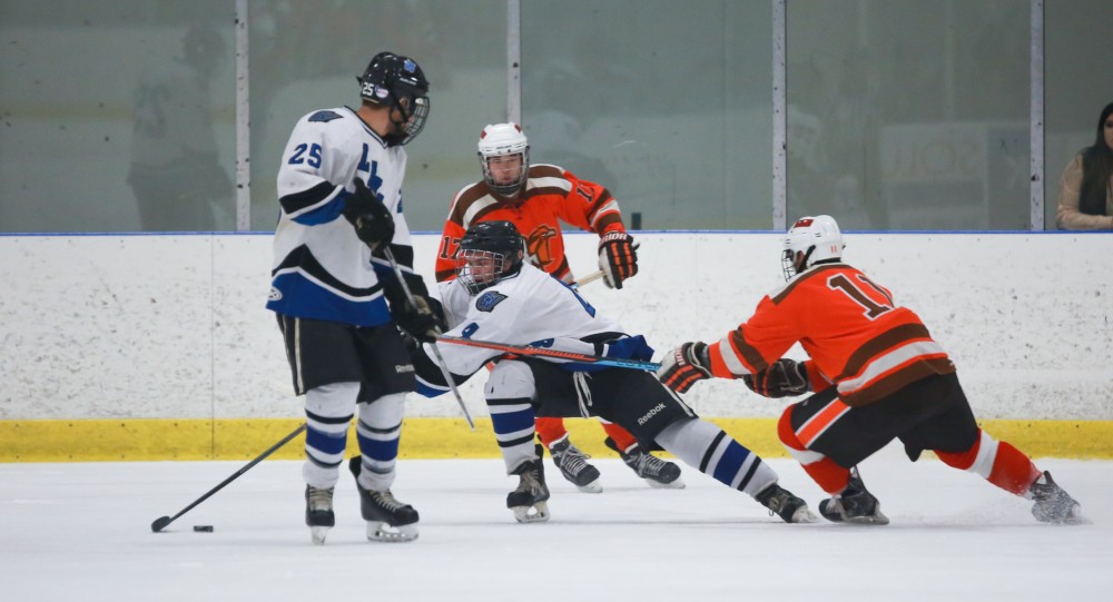 GVL / Kevin Sielaff - Tom Lusynski (4) swivels the puck around a Falcon attacker. Grand Valley's Divison II men's hockey squad squares off against Bowling Green University Oct. 16 at Georgetown Ice Arena.