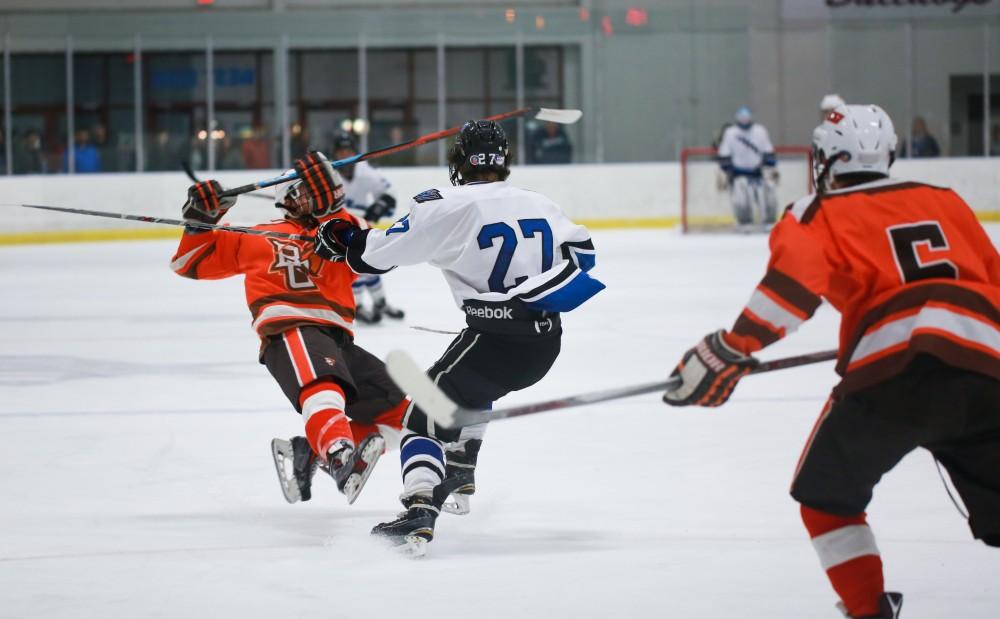 GVL / Kevin Sielaff - Corbin Rainey (27) delivers a strong hit. Grand Valley's Divison II men's hockey squad squares off against Bowling Green University Oct. 16 at Georgetown Ice Arena.