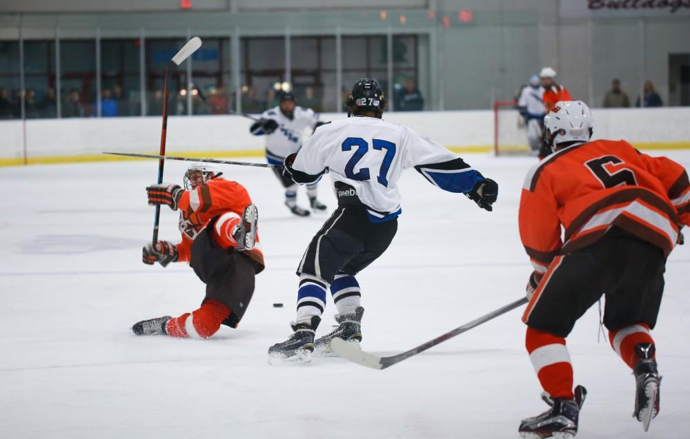 GVL / Kevin Sielaff - Corbin Rainey (27) delivers a strong hit. Grand Valley's Divison II men's hockey squad squares off against Bowling Green University Oct. 16 at Georgetown Ice Arena.