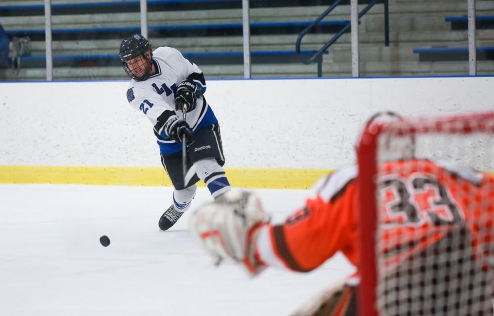 GVL / Kevin Sielaff - Ian Homilton (21) fires a shot. Grand Valley's Divison II men's hockey squad squares off against Bowling Green University Oct. 16 at Georgetown Ice Arena.