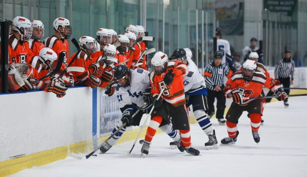 GVL / Kevin Sielaff - Ian Hamilton (21) is pinned up against Bowling Green's boards as he tries to gain posession of the puck. Grand Valley's Divison II men's hockey squad squares off against Bowling Green University Oct. 16 at Georgetown Ice Arena.