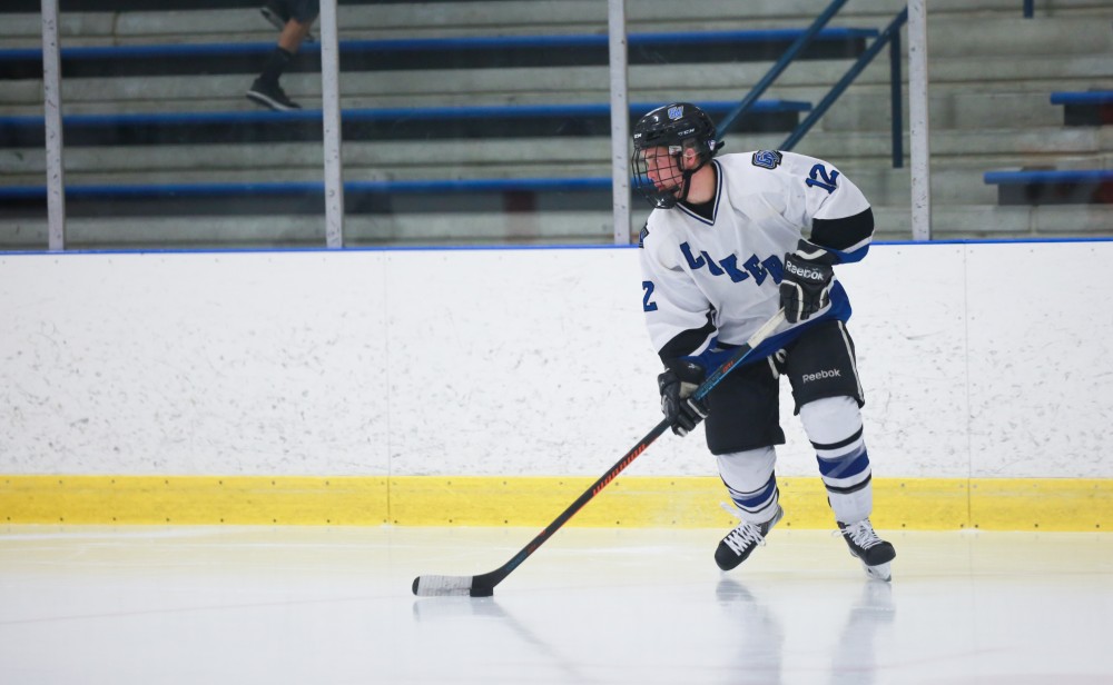 GVL / Kevin Sielaff - Reede Burnett (12) moves the puck near the neutral zone. Grand Valley's Divison II men's hockey squad squares off against Bowling Green University Oct. 16 at Georgetown Ice Arena.