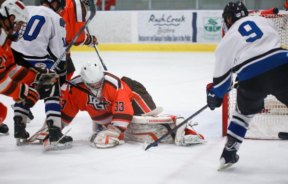 GVL / Kevin Sielaff - Spencer Godin (9) attempts to flick the puck over the pads of Jacob Butler (33). Grand Valley's Divison II men's hockey squad squares off against Bowling Green University Oct. 16 at Georgetown Ice Arena.