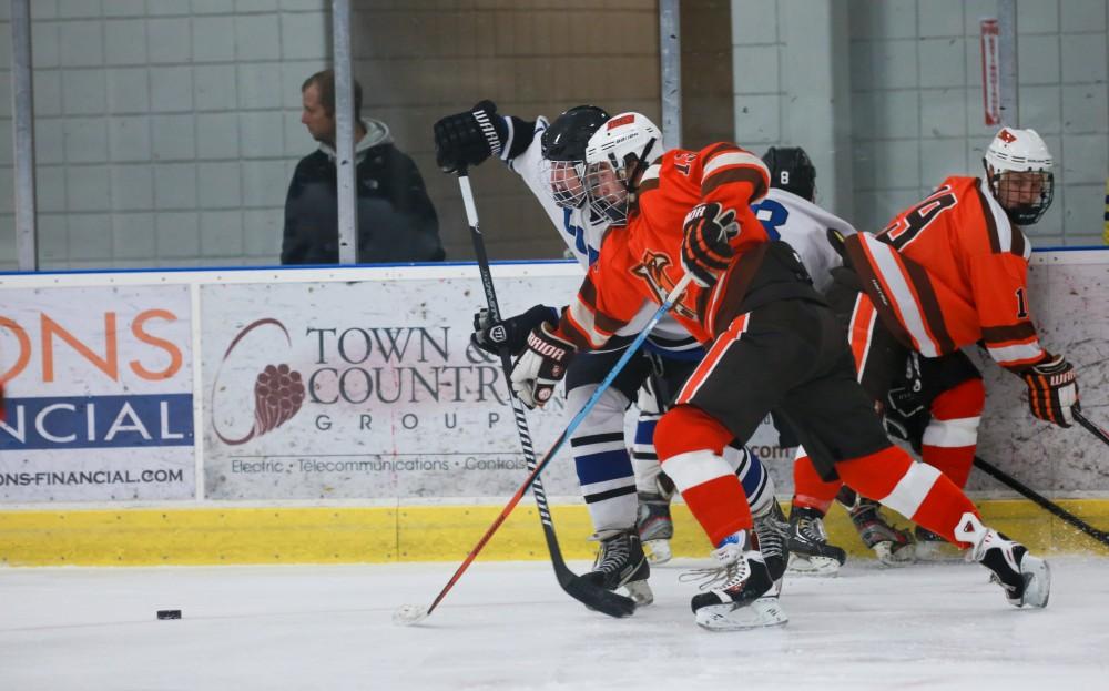 GVL / Kevin Sielaff - Zac Strain (22) fights for the puck in the neutral zone. Grand Valley's Divison II men's hockey squad squares off against Bowling Green University Oct. 16 at Georgetown Ice Arena.