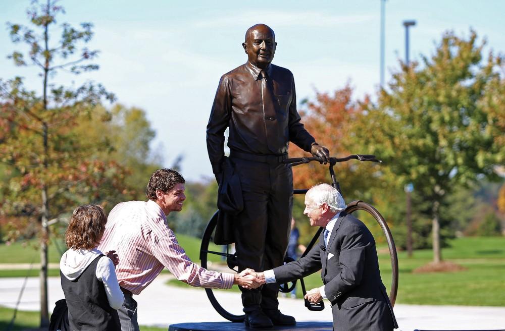 GVL ArchiveArtist J. Brett Grill (left) shakes hands with David Frey (right) during the inaugural Founders Day event and unveiling of the L. William Seidman statue. Grill was commisioned to create the statue of Seidman. 