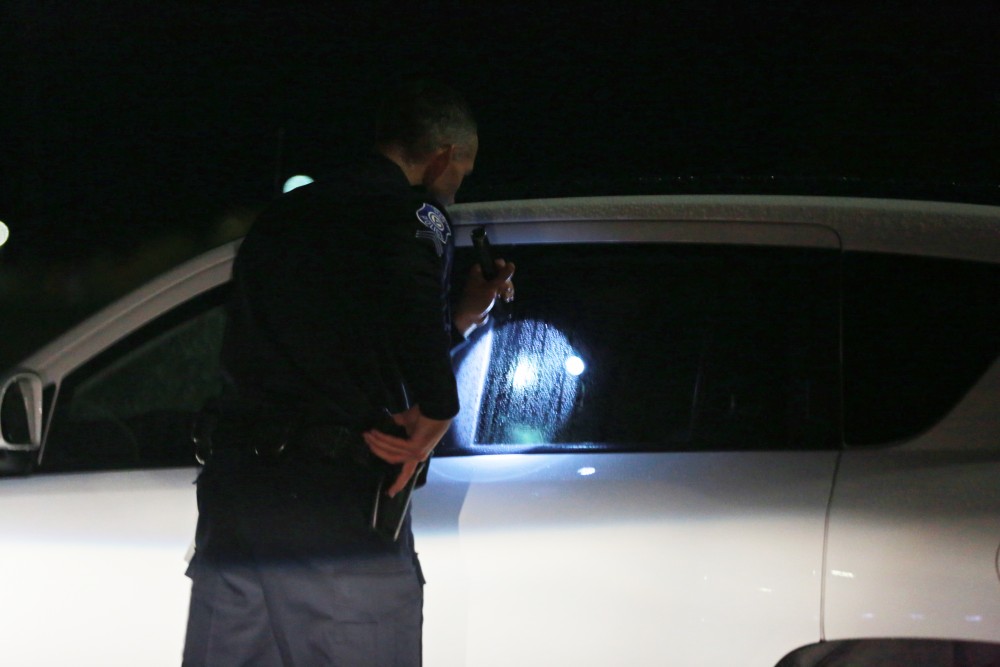 GVL / Kevin Sielaff - Sgt. Jeff Stoll assists his fellow officers as they search parking lot G for a suspicous male subject on Oct. 25.