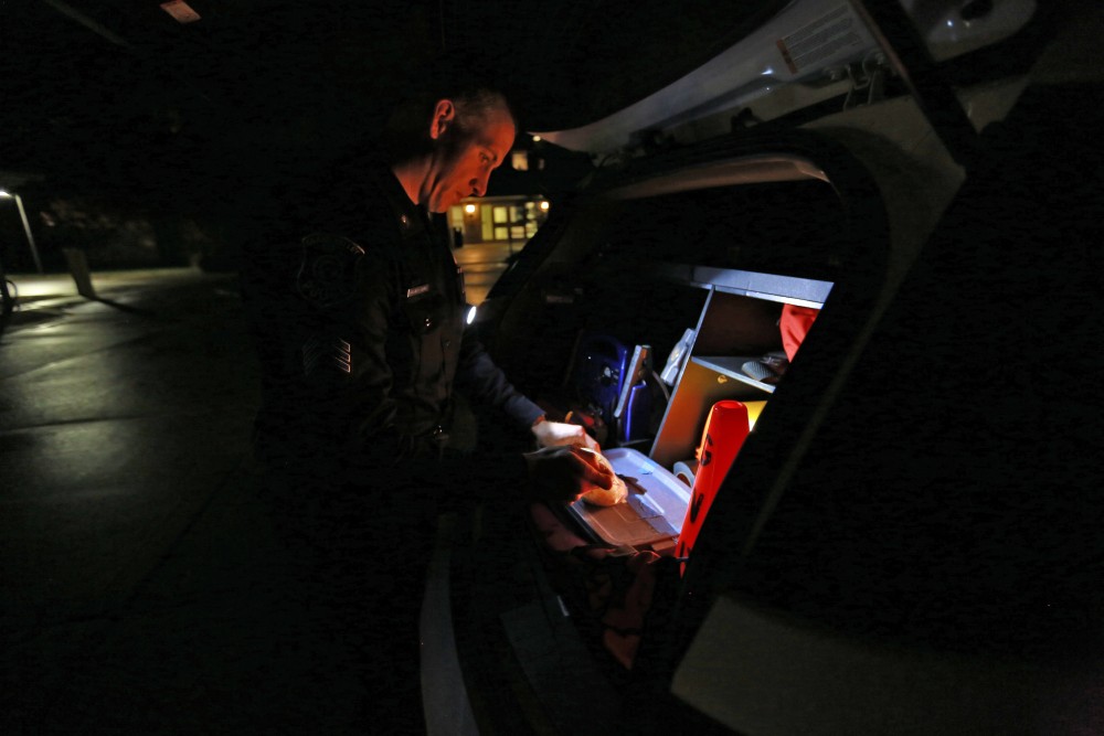 GVL / Kevin Sielaff - Sgt. Jeff Stoll puts on gloves as he prepares to assist with a medical call within Swanson living center on Oct. 25.