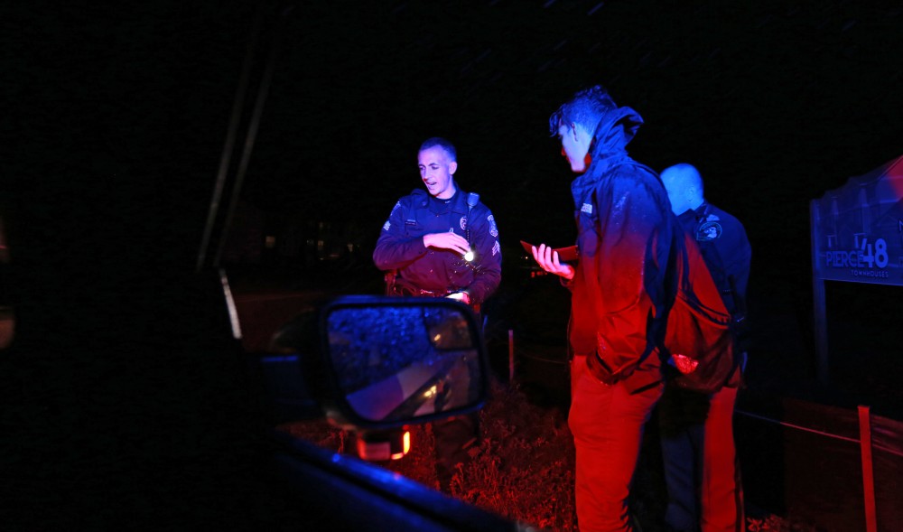 GVL / Kevin Sielaff - Sgt. Jeff Stoll helps an intoxicated individual find his way back home on the corner of Pierce street and 48th avenue on Oct. 25. 