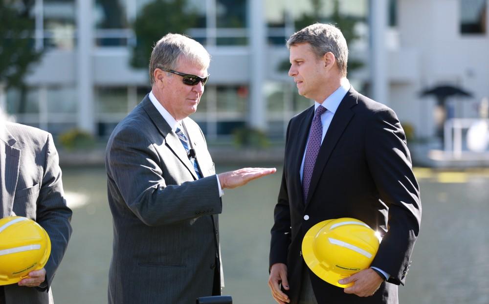 GVL / Kevin Sielaff - President Thomas Haas speaks with congressman Bill Huizenga after the ground breaking. Officials break ground on Grand Valley's solar garden Oct. 2 in Allendale. By next spring, 17 acres of land near 48th avenue will be generating 3 megawatts of electricity for the community.