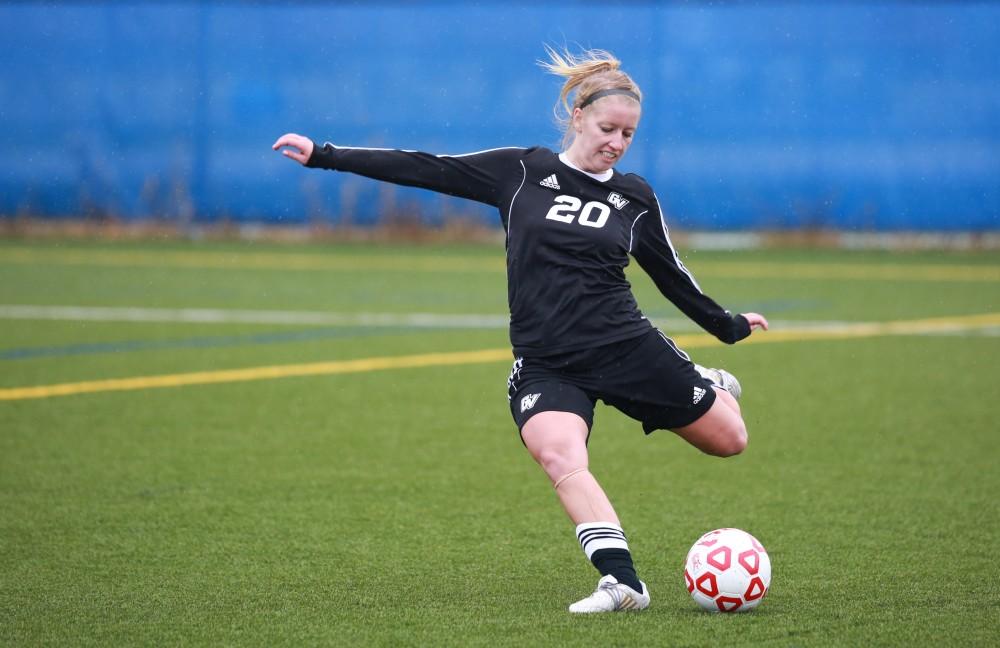 GVL / Kevin Sielaff - Jenny Winters (20) drills the ball down field.  Grand Valley's women's club soccer team squares off against Michigan State on a rainy Oct. 31. The Lakers were defeated, with a final score of 2-0 in favor of Michigan State.