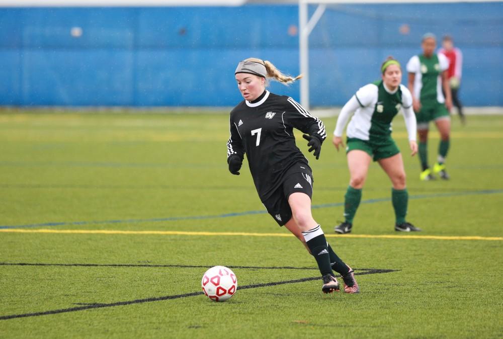 GVL / Kevin Sielaff - Rachel Hoegeman (7) dribbles the ball down field.  Grand Valley's women's club soccer team squares off against Michigan State on a rainy Oct. 31. The Lakers were defeated, with a final score of 2-0 in favor of Michigan State.