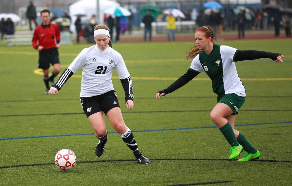 GVL / Kevin Sielaff - Casey Thorn (21) swivels the ball away from a State forward.  Grand Valley's women's club soccer team squares off against Michigan State on a rainy Oct. 31. The Lakers were defeated, with a final score of 2-0 in favor of Michigan State.