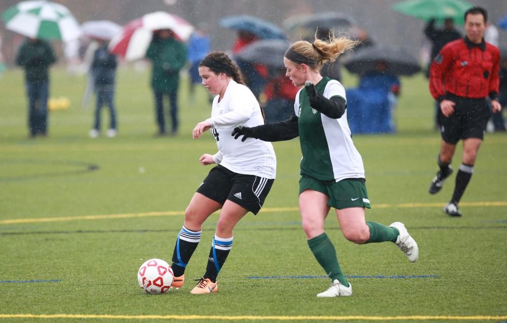 GVL / Kevin Sielaff -  Lindsay Straw (14) passes the ball away.  Grand Valley's women's club soccer team squares off against Michigan State on a rainy Oct. 31. The Lakers were defeated, with a final score of 2-0 in favor of Michigan State.