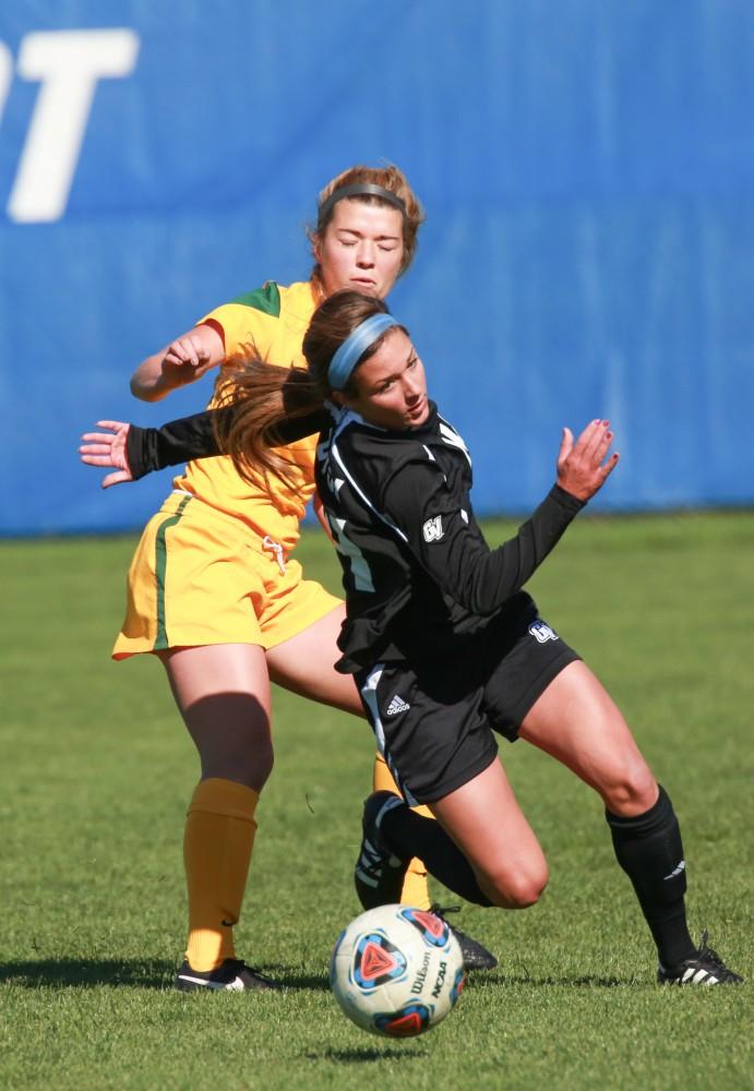 GVL / Kevin Sielaff - Mackenzie Fox (14) is tripped while heading down field.  Grand Valley's women's soccer team squares off against Northern Michigan Oct. 18 and wins with a final score of 7-0.