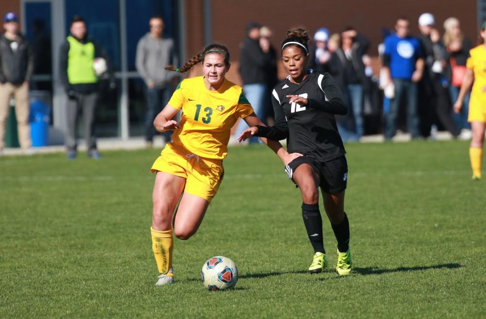 GVL / Kevin Sielaff -  Jayma Martin (12) fights for field position with Northern's Sophie Sachs (13).  Grand Valley's women's soccer team squares off against Northern Michigan Oct. 18 and wins with a final score of 7-0.