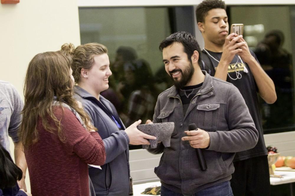 GVL / Sara Carte
Mexican artist, Roli Mancera, gives objects to students to place onto the alter in celebration of the Day of the Dead at the Honors college in Allendale’s Campus on Nov. 2.