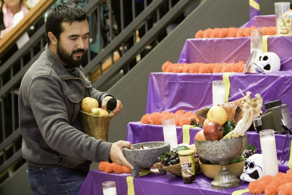 GVL / Sara Carte
Mexican artist, Roli Mancera, places objects onto the alter in celebration of the Day of the Dead at the Honors college in Allendale’s Campus on Nov. 2.