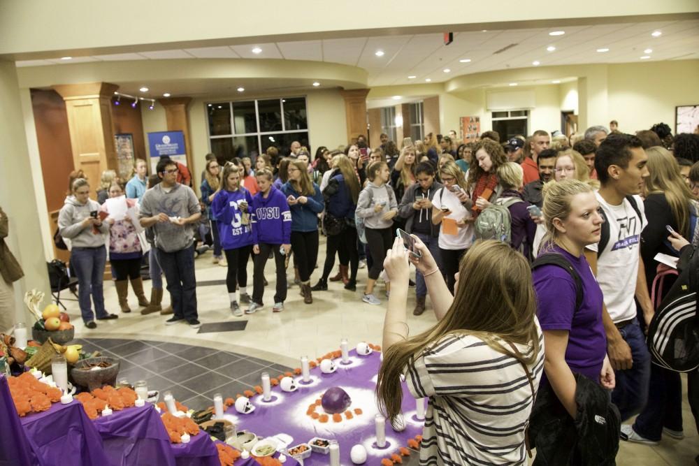 GVL / Sara Carte
Students and families gather around the alter, a Day of the Dead holiday tradition, for the celebration of  Day of the Dead at the Honors College on Allendale’s Campus on Nov. 2.